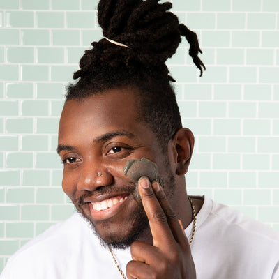 black male using bentonite clay facial mask